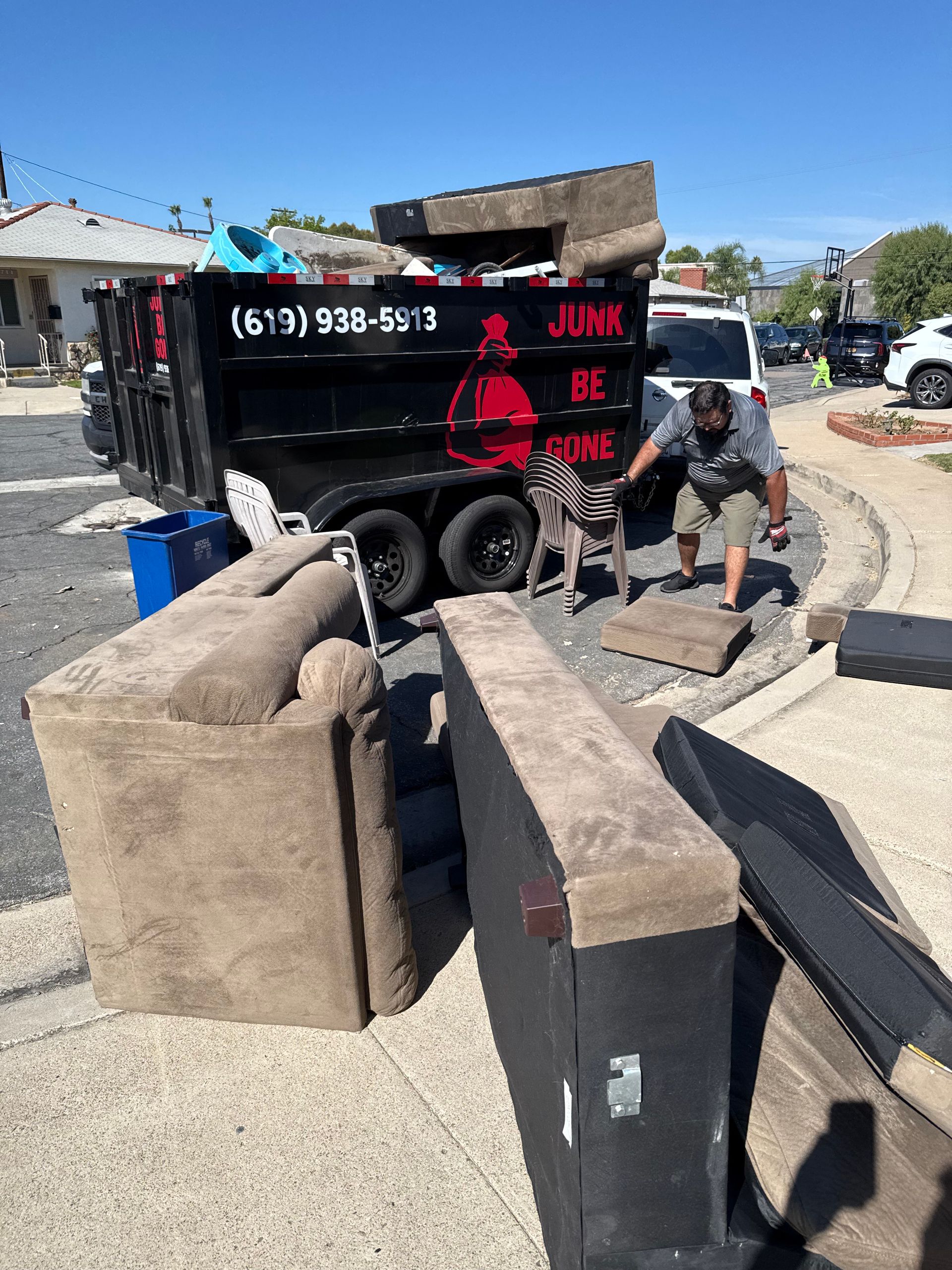 Pile of wooden planks on grass next to a brick border.
