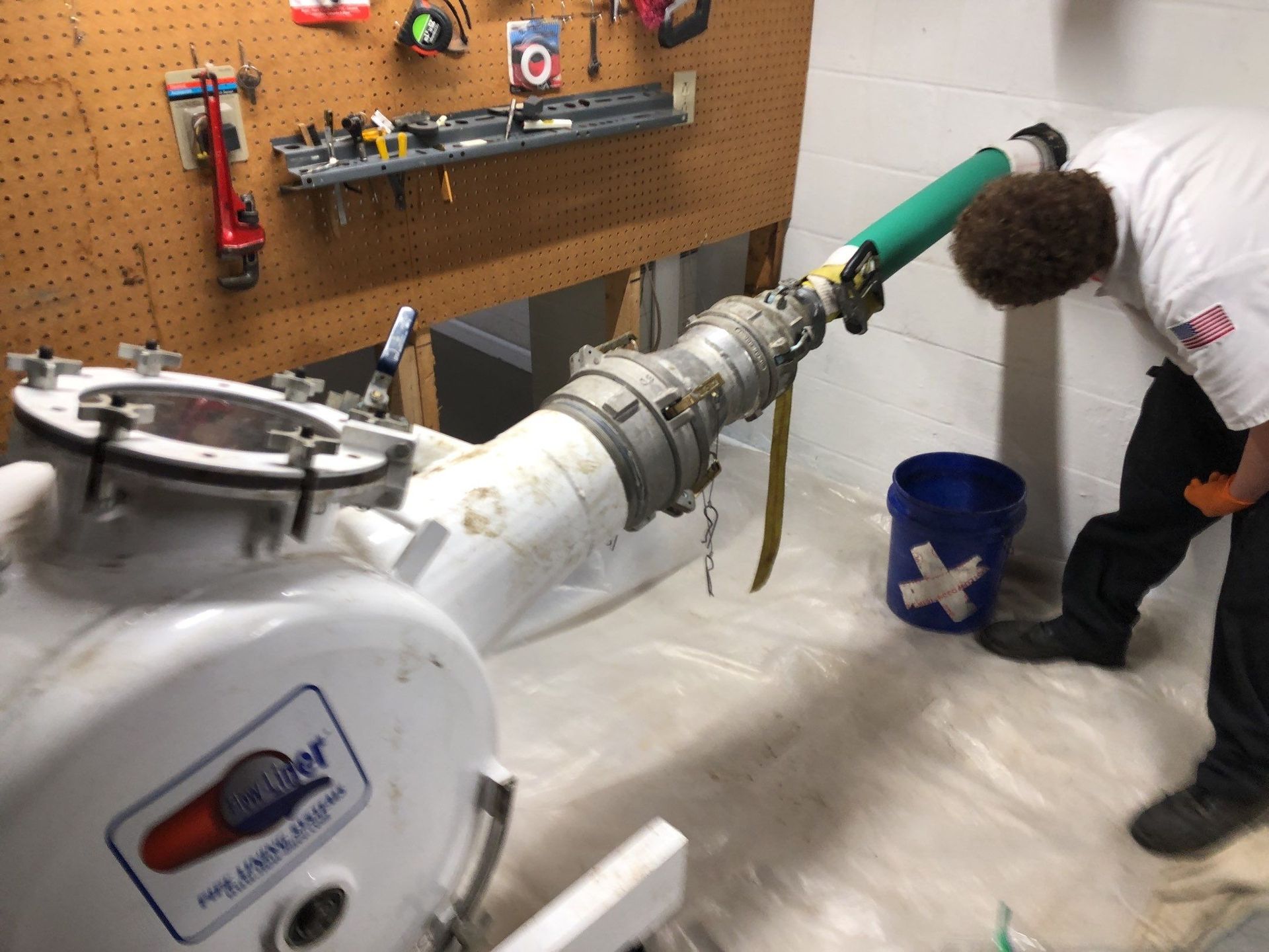 Plumber unclogging blocked shower drain with hydro jetting
