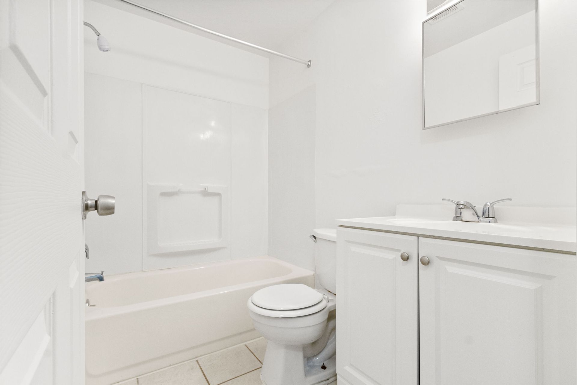 White bathroom with a tub, toilet, and sink.