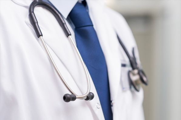 A close up of a doctor with a stethoscope around his neck