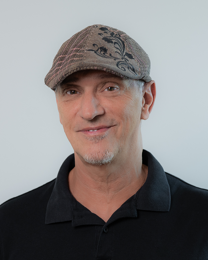 A man in a suit and white shirt is smiling for the camera