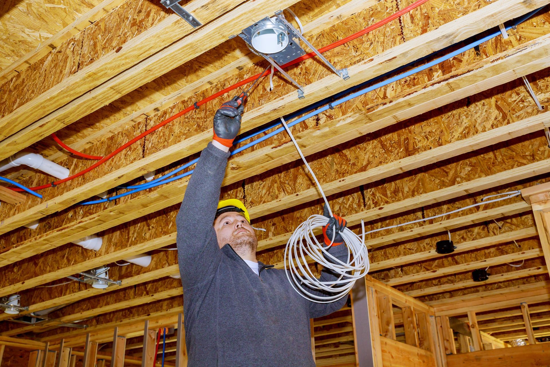 A man is working on a ceiling in a house under construction.