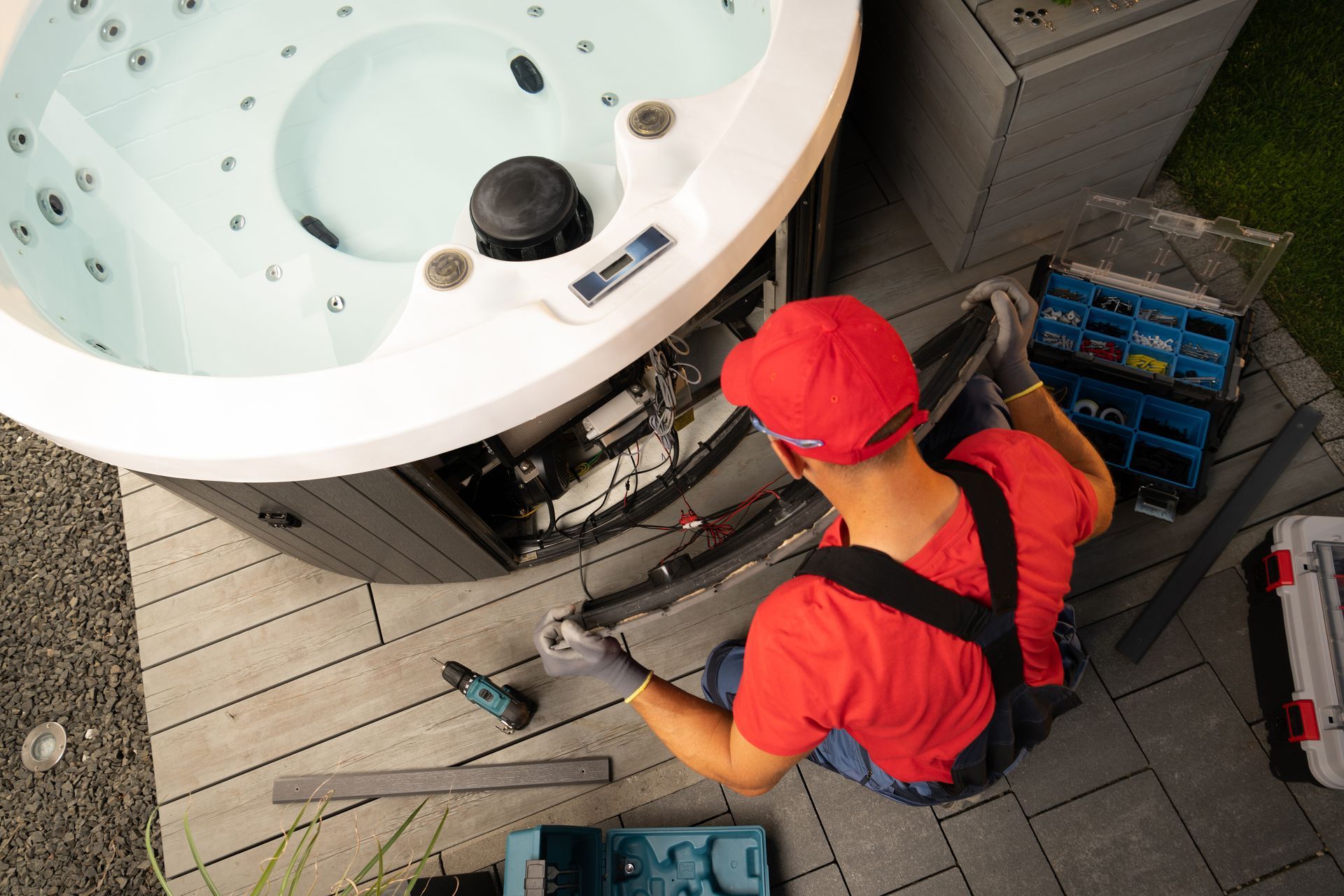 A man is working on a hot tub on a deck.