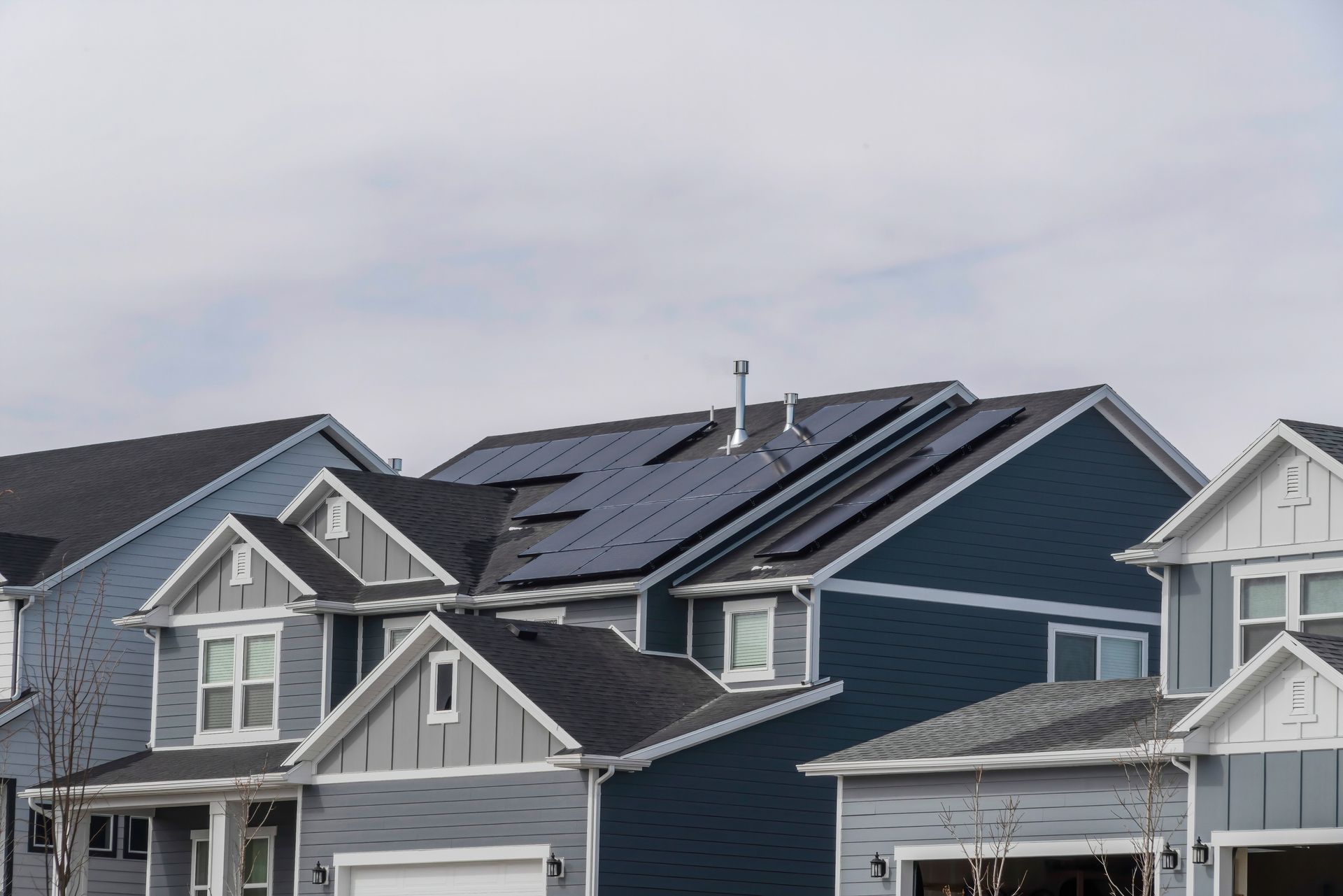 A white house with an orange tiled roof and solar panels, surrounded by a vibrant field of orange marigolds.