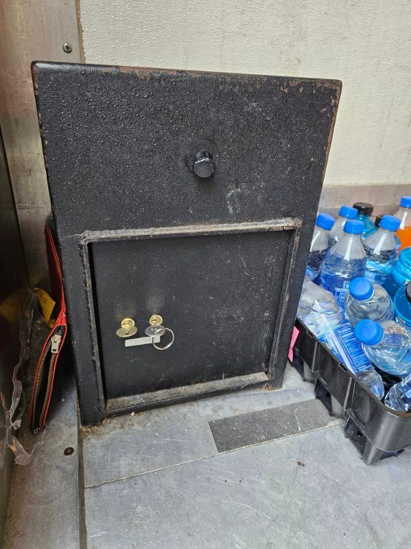 A black box is sitting next to a pile of bottles of water.