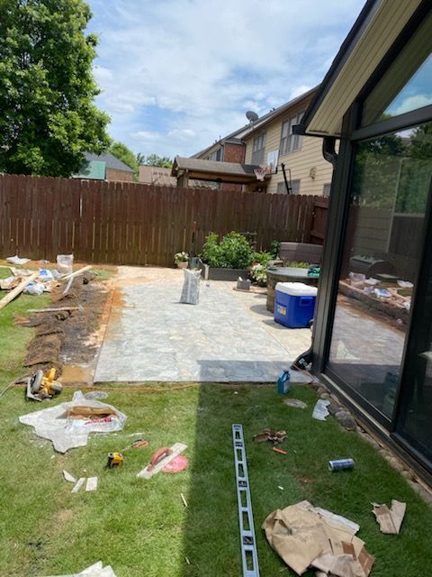 A patio is being built in the backyard of a house.