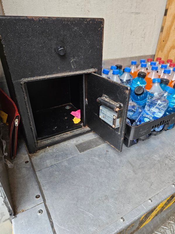 A safe filled with water bottles is sitting on a table.