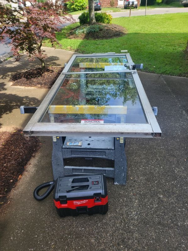 A piece of glass is sitting on a table next to a vacuum cleaner