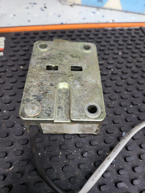 A piece of metal is sitting on top of a black mat.