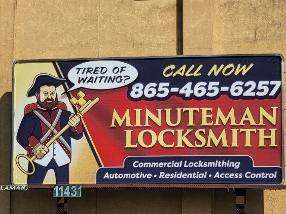 A billboard for minuteman locksmith shows a man holding a key