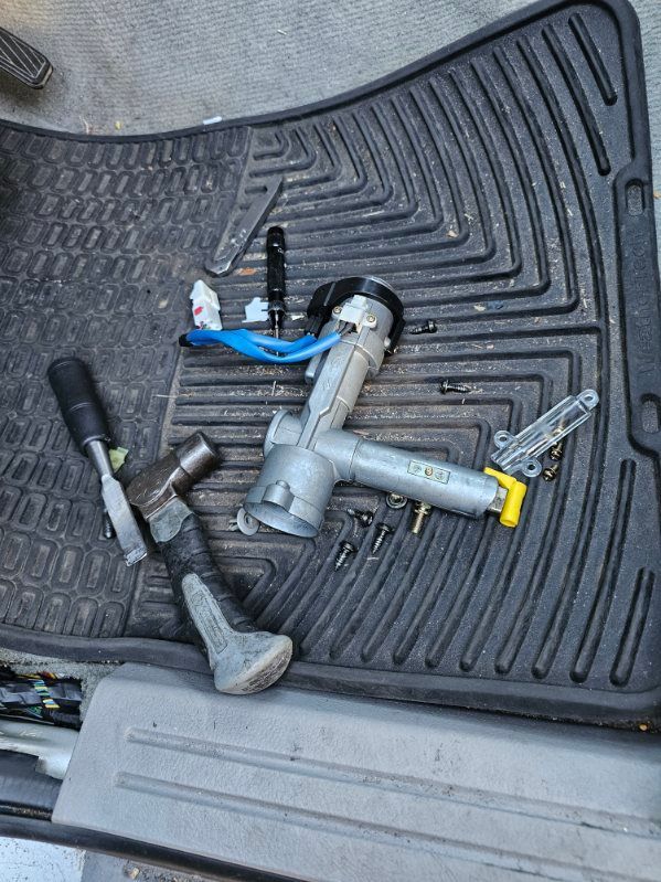 A broken steering lock is sitting on top of a car mat.