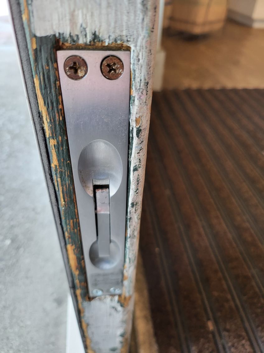 A close up of a door lock on a wooden door.