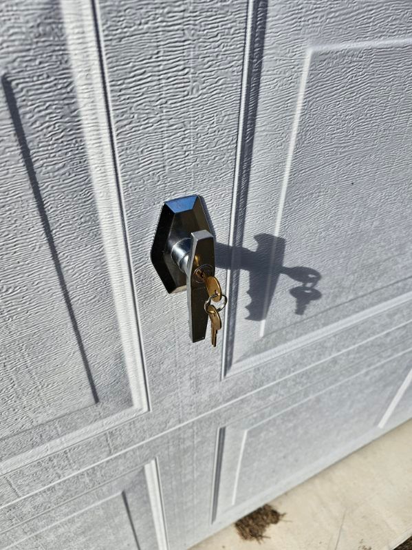 A close up of a garage door with a key in it.