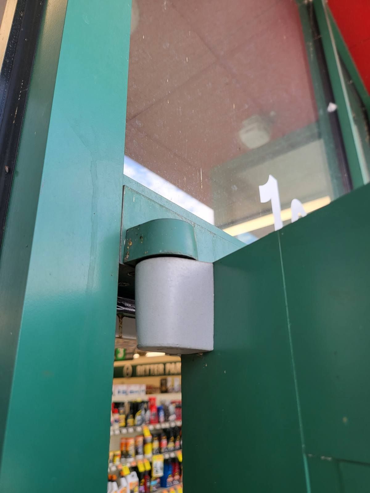 A green door is open to a store with the number 1 on it