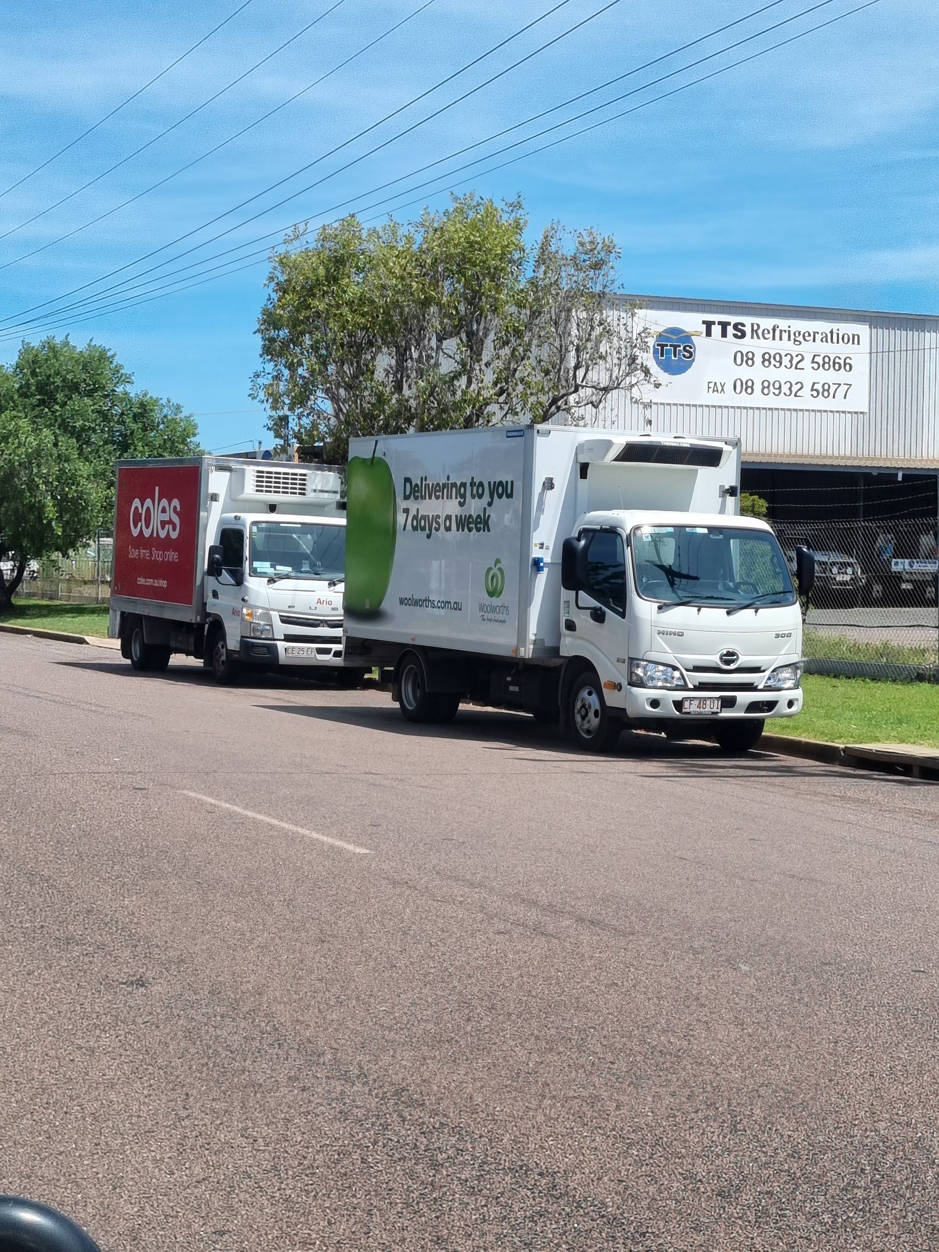 Three white delivery trucks parked on a road in front of a building on a sunny day — TTS Refrigeration in Pinelands, NT