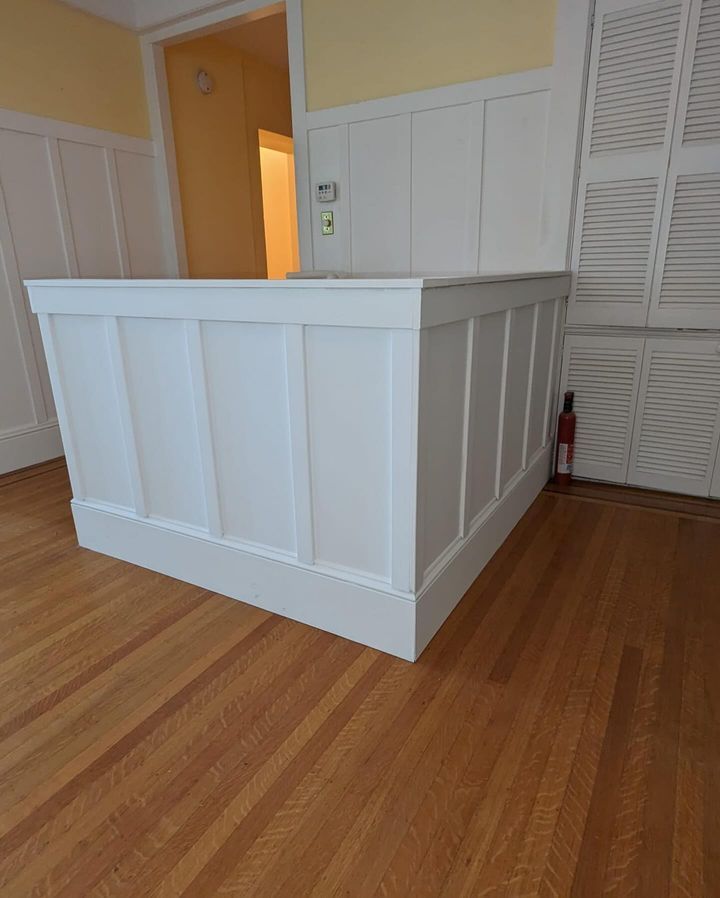 A white box is sitting on a wooden floor in a room.