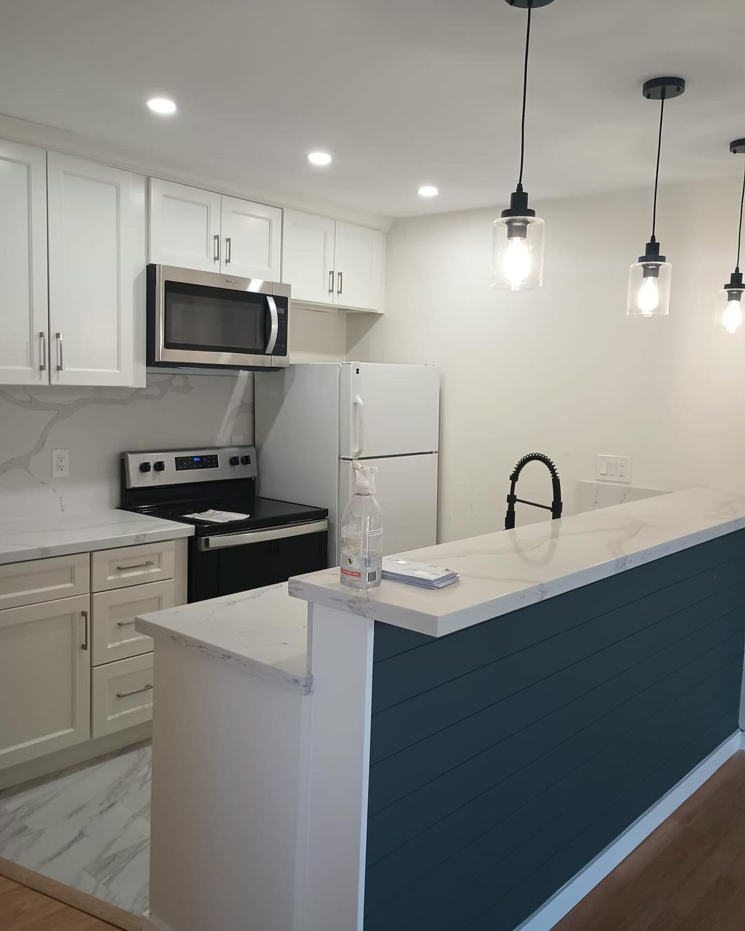 A kitchen with white cabinets and a blue counter top