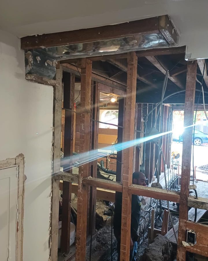 A room with a lot of wooden beams and a light coming out of the ceiling.