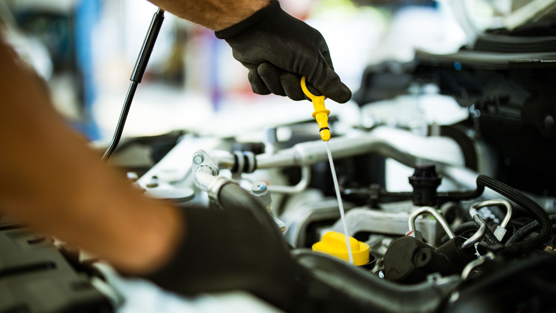 A man is checking the oil level of a car.