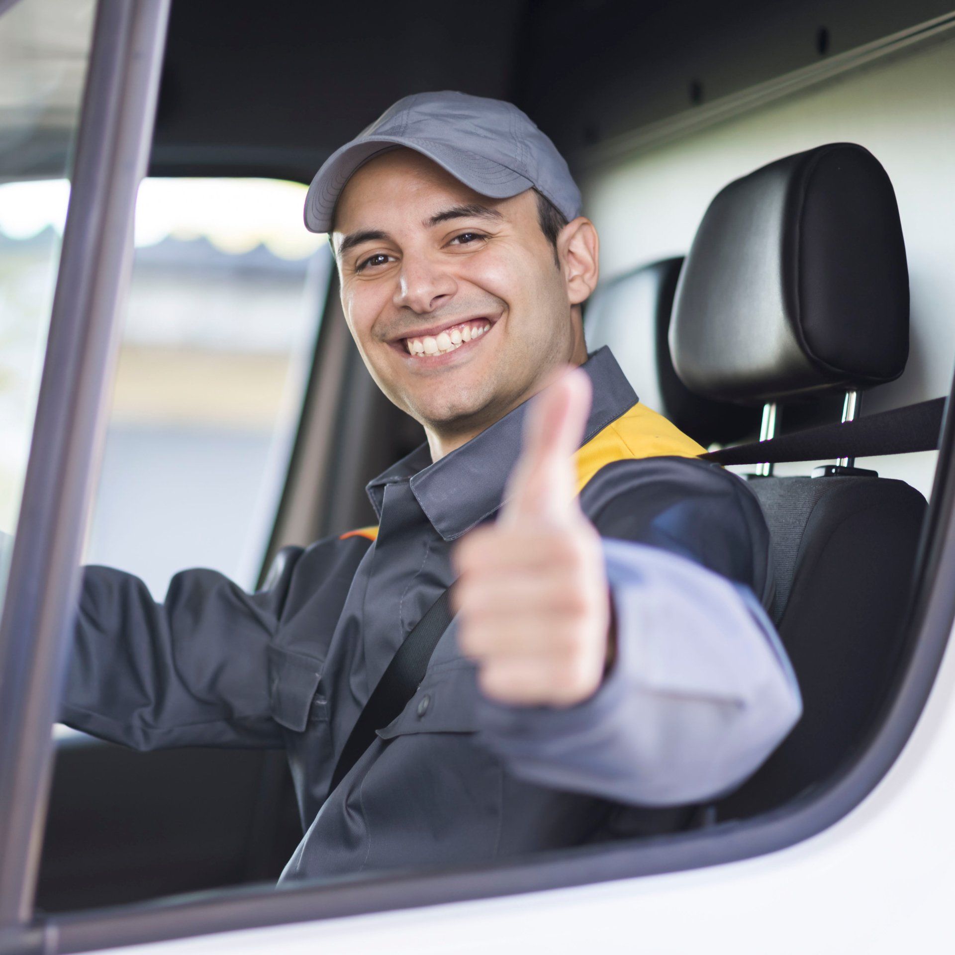 A man in a truck is giving a thumbs up