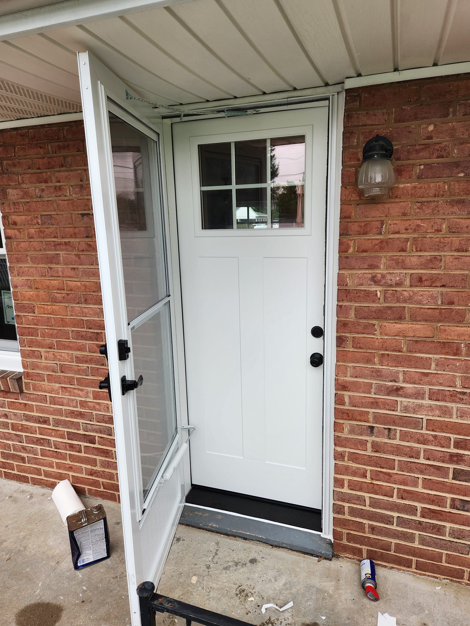 A white door is sitting on top of a brick wall.