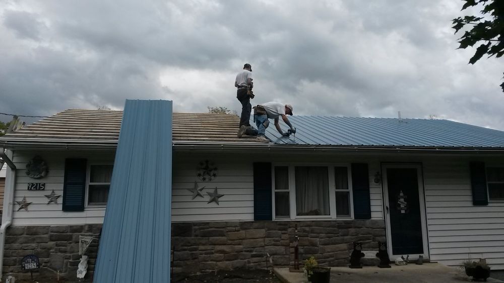 Two men are working on the roof of a house