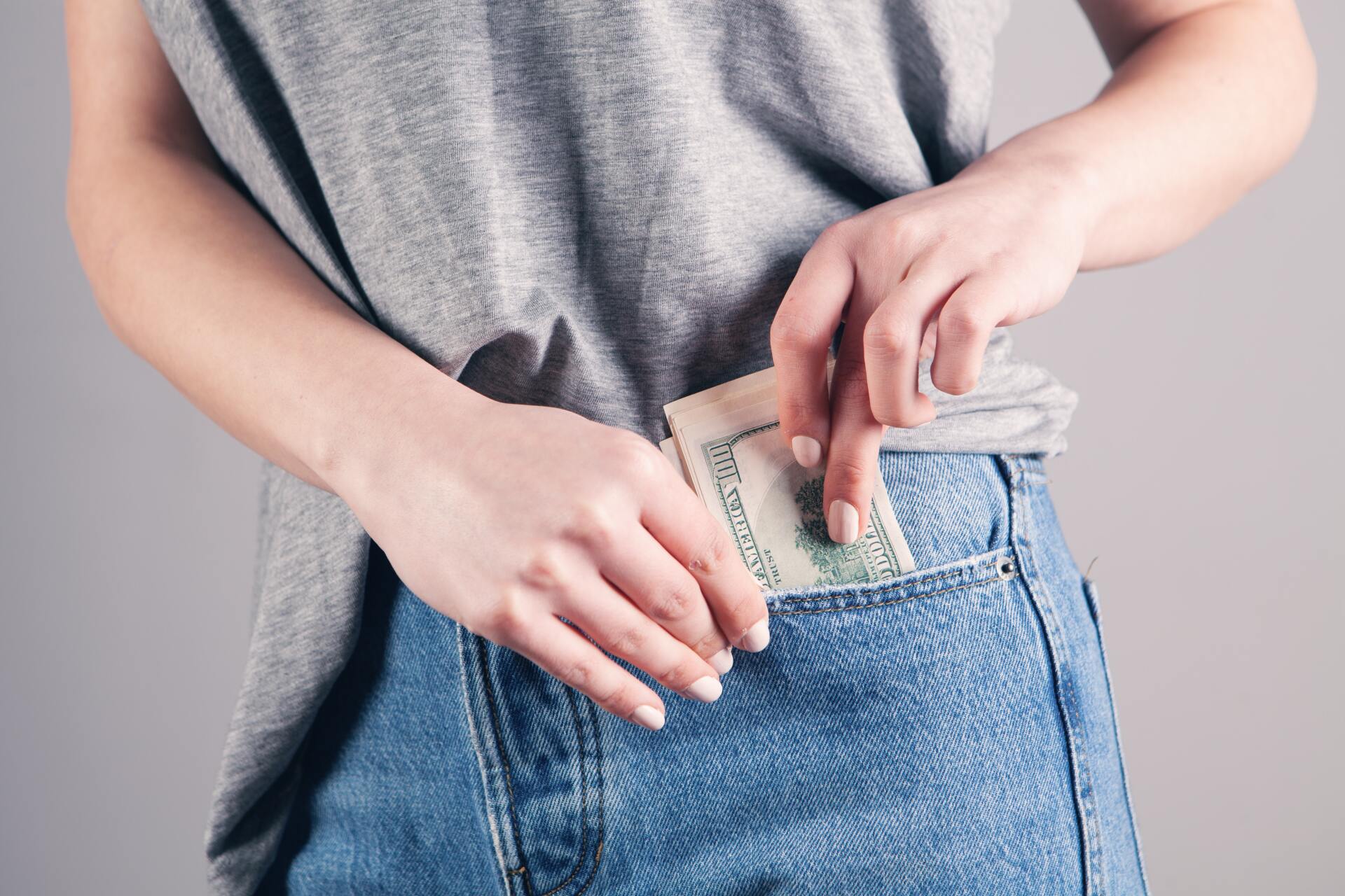 mujer guardando dinero en su pantalón mujer guardando dinero en su pantalón
