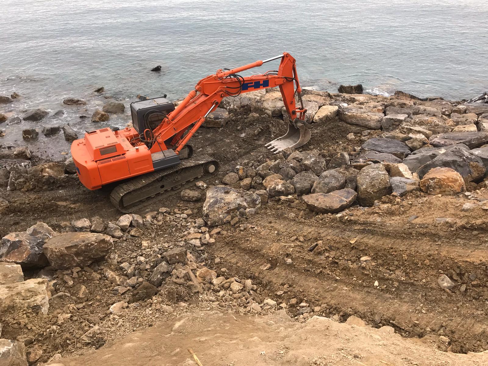 escavatrice al lavoro in spiaggia