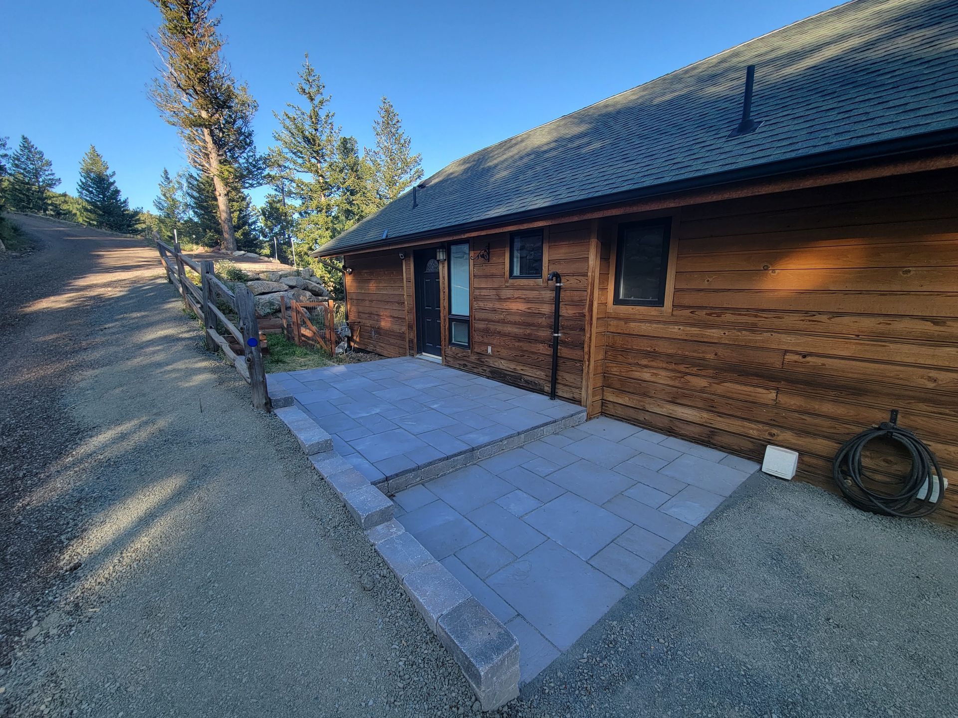 A log cabin with a patio in front of it.