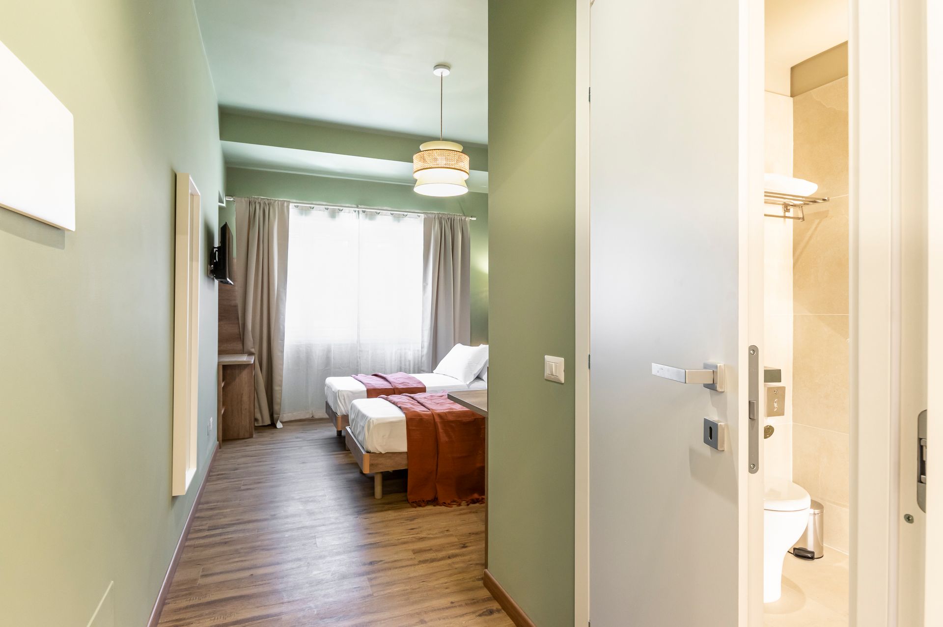 Una camera d'albergo con due letti e un bagno