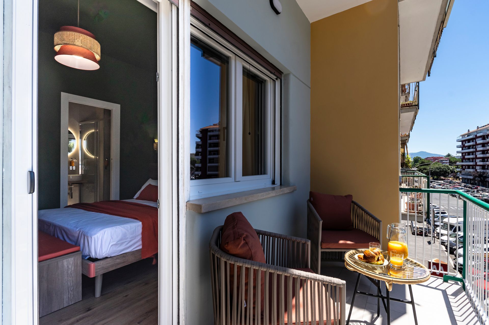 Un balcone con una sedia e un tavolo di fronte a una camera da letto