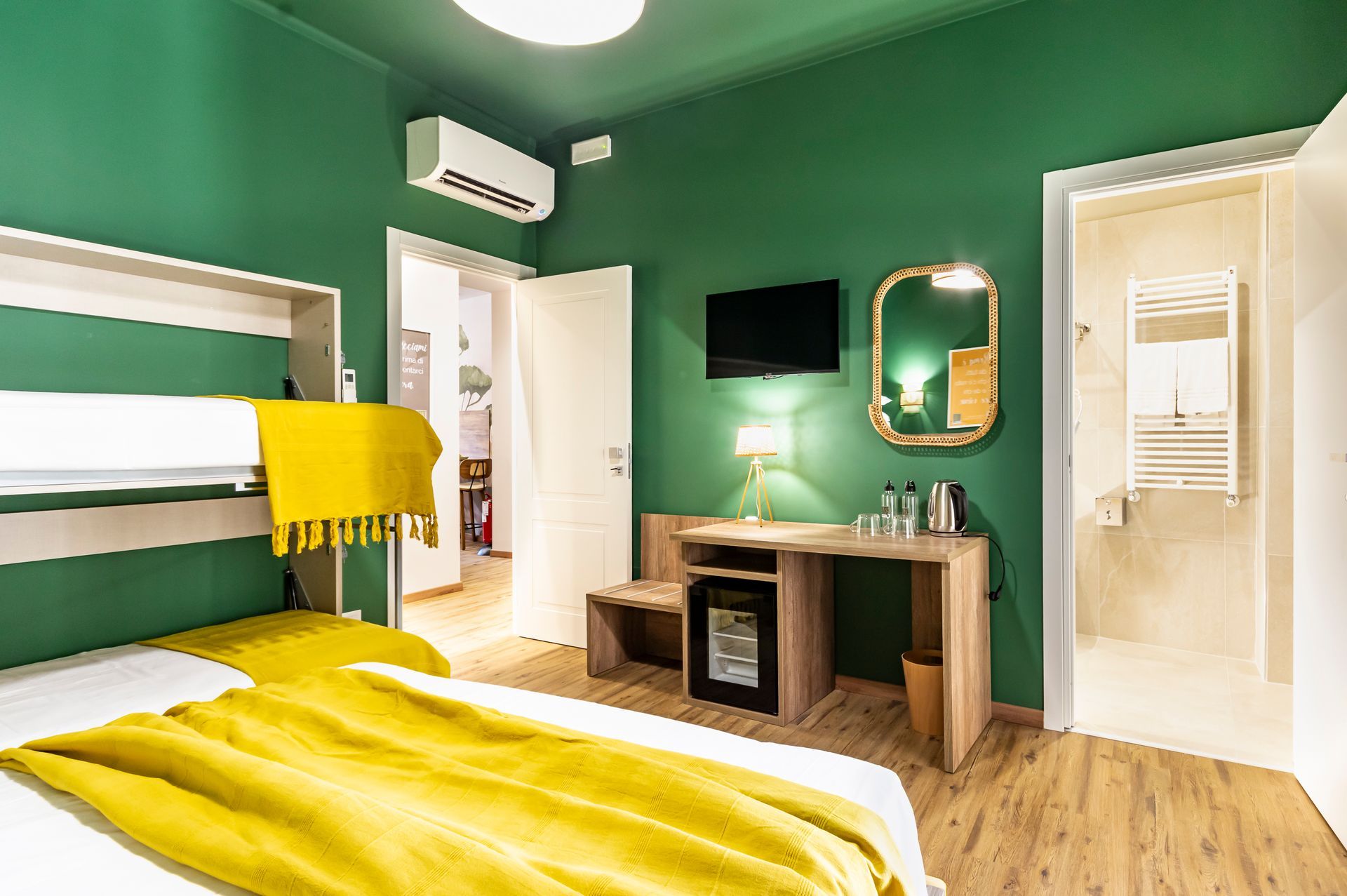 Una camera da letto con pareti verdi e una coperta gialla sul letto