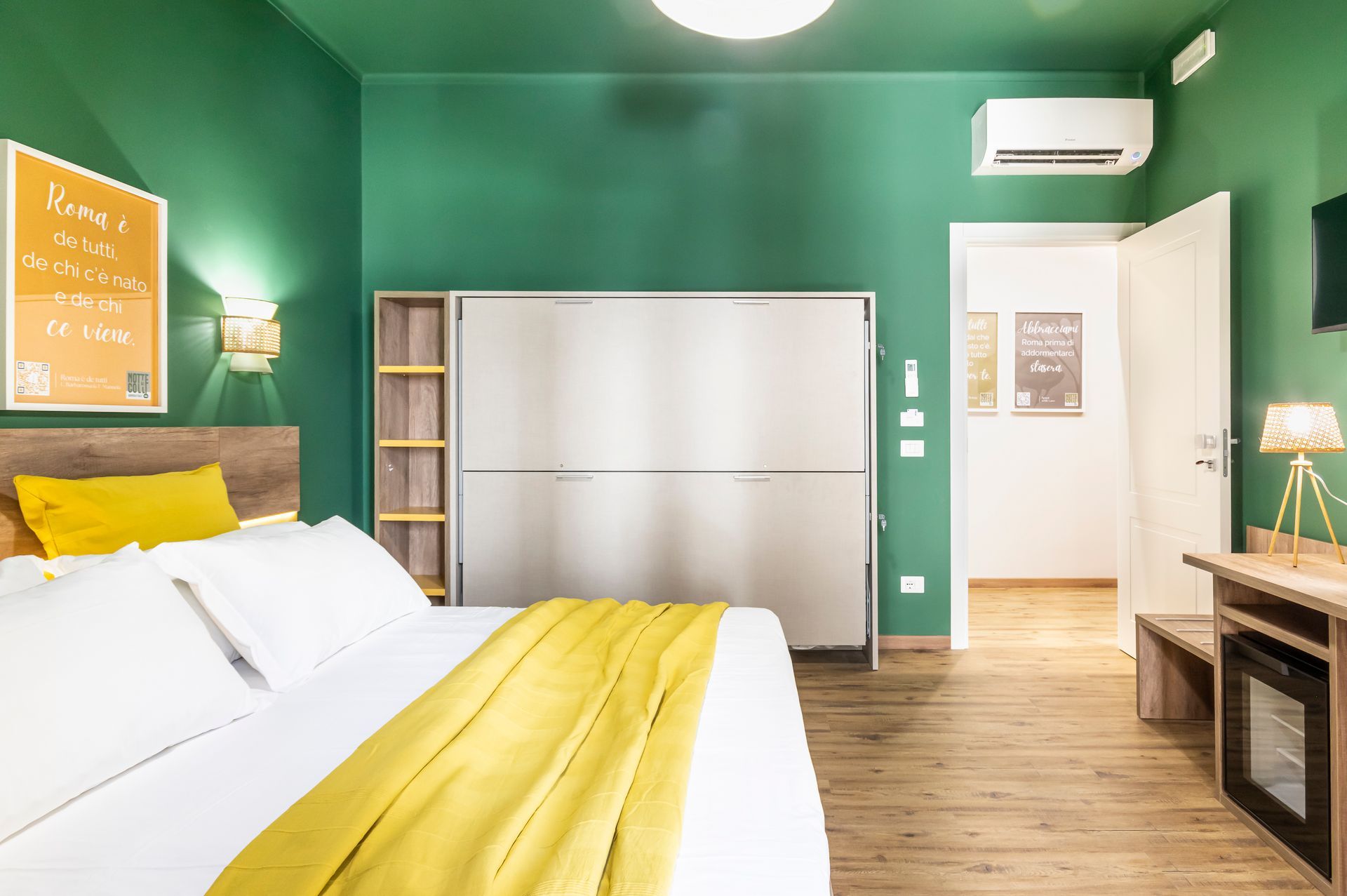 Una camera da letto con pareti verdi e un letto con una coperta gialla