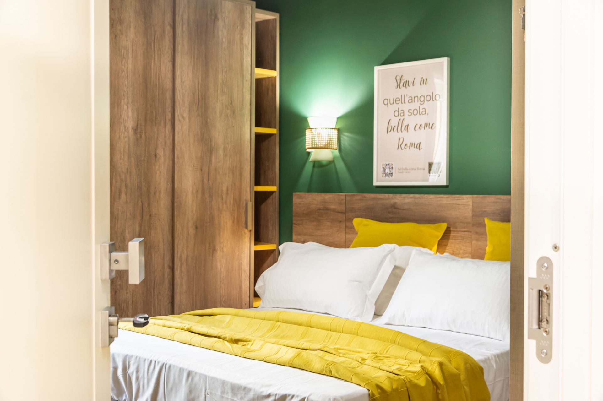 Una camera da letto con pareti verdi e un letto con una coperta gialla