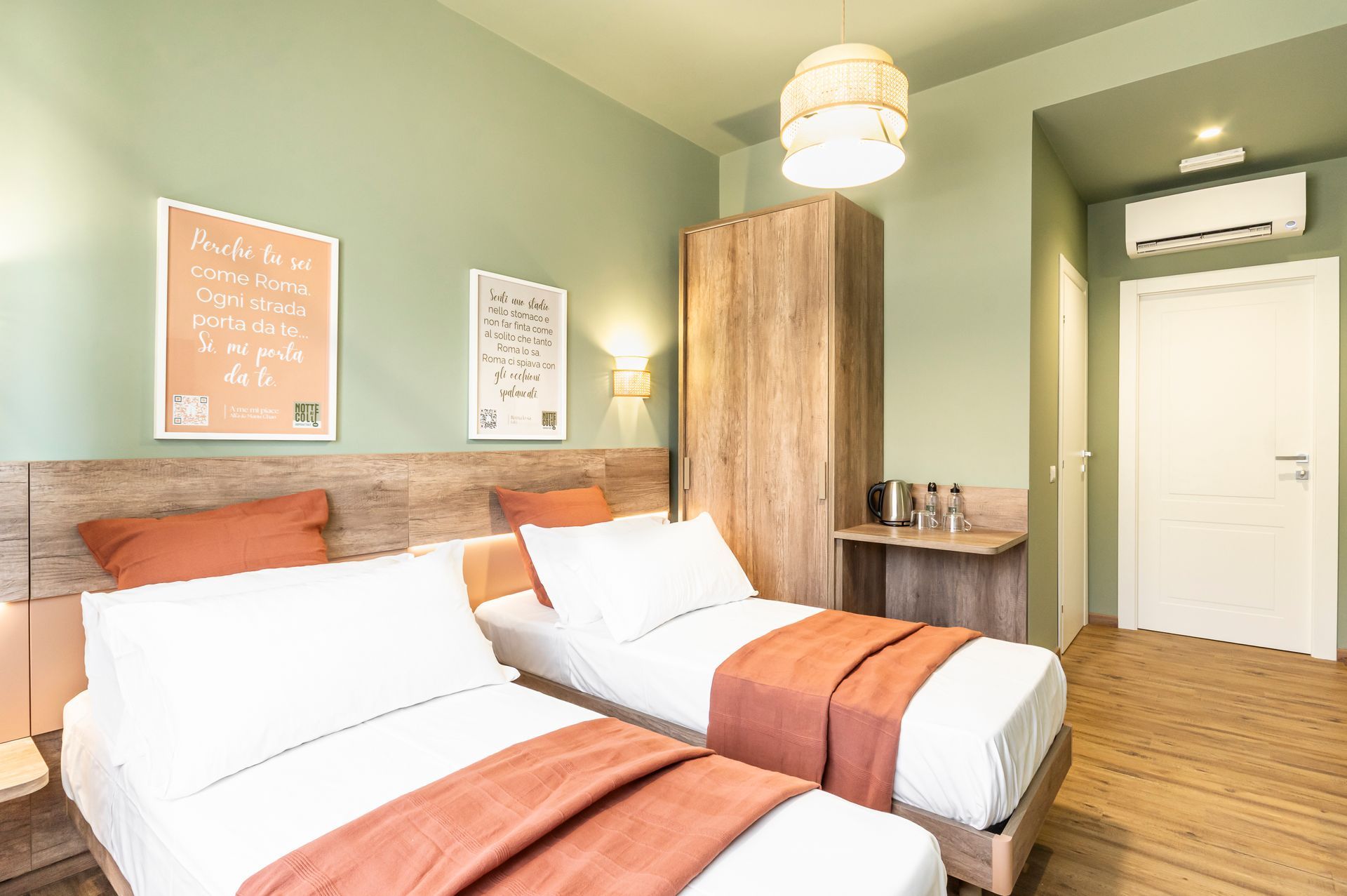 Una camera da letto con due letti e pareti verdi