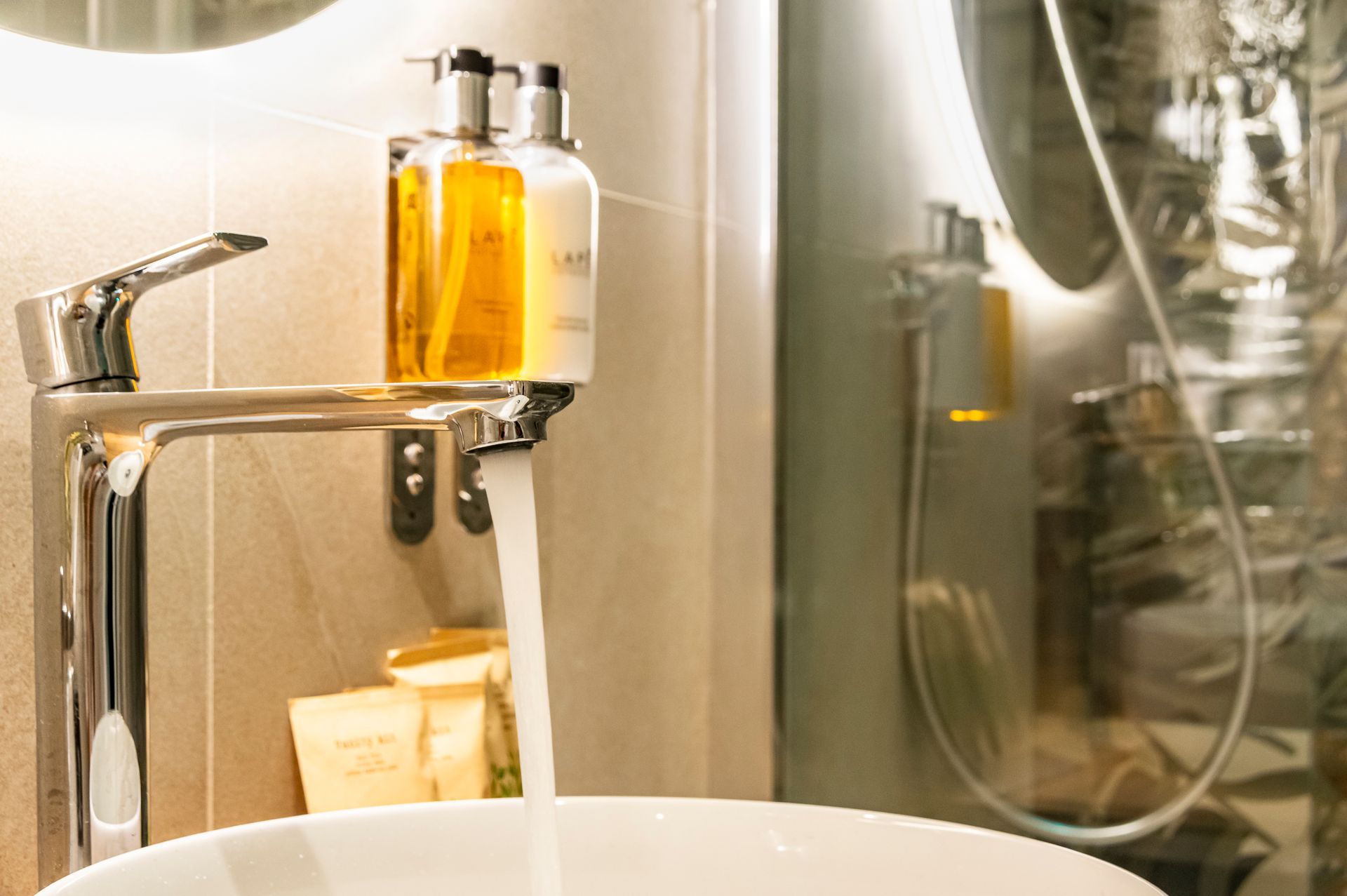 Un lavandino del bagno con un distributore di sapone a parete