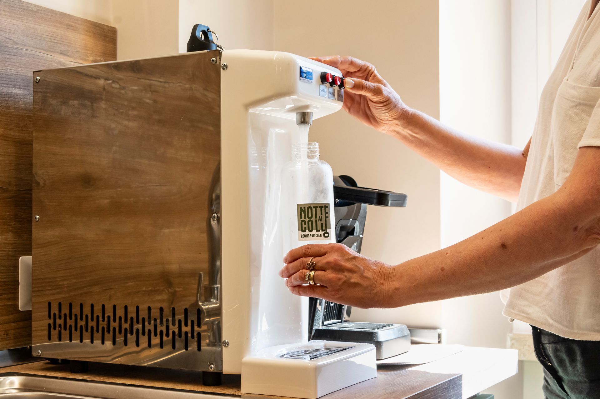 Una persona sta versando acqua in una bottiglia su cui è scritto Pete Gull