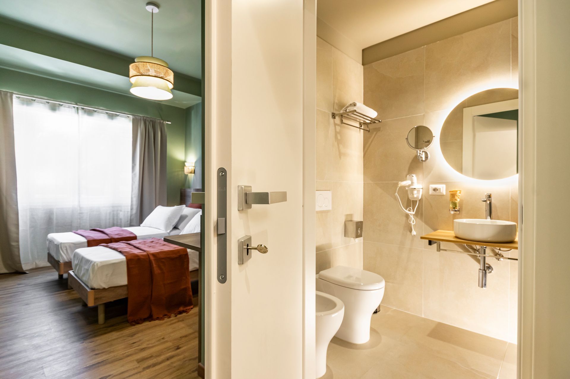 Una camera d'albergo con due letti e un bagno