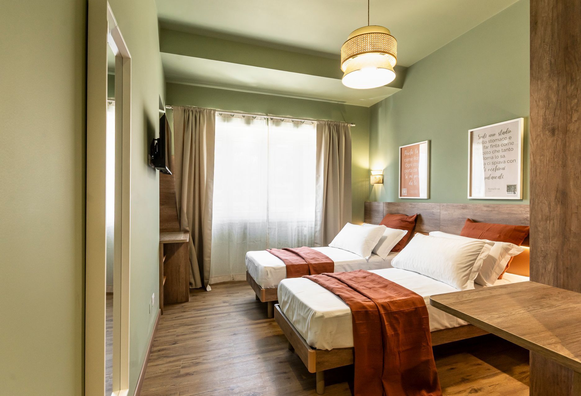 Una camera d'albergo con due letti e una televisione