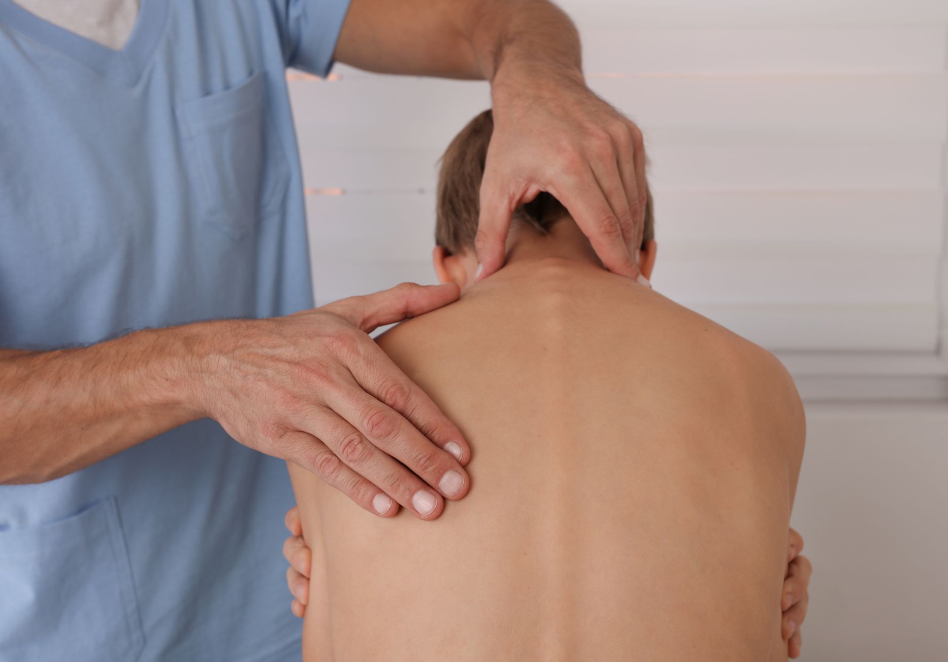 Masseur treats a patient by sports injury massage