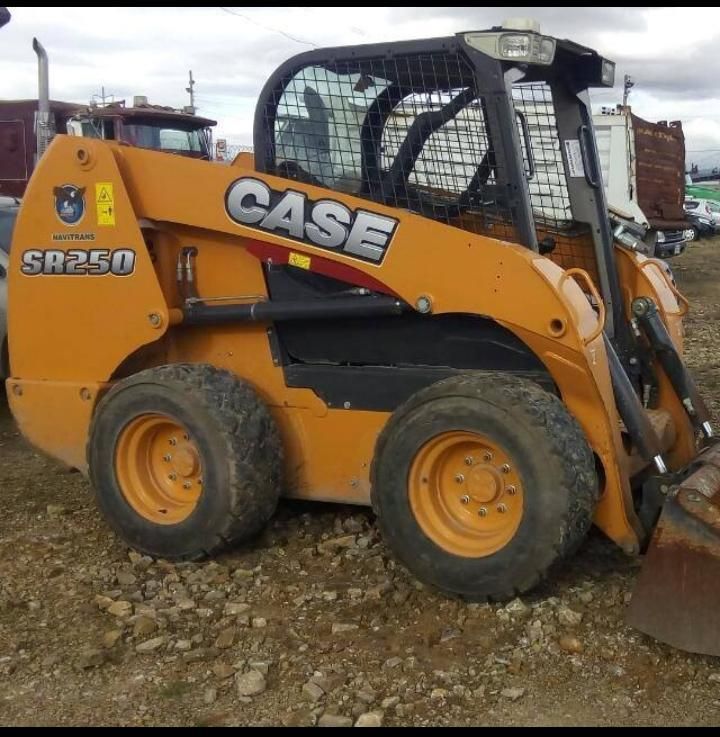 Minicargadora CASE SR250 amarilla en un terreno de grava, vista de lado.