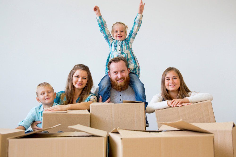 Family laying on moving boxes  — Removalists in Sunshine Coast