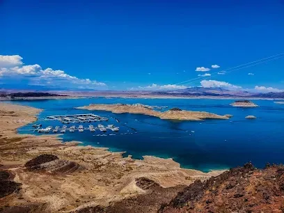 Mobile IVTherapyLas Vegas-Expansive view of a serene lake with scattered islands under a bright blue sky. A marina with boats is visible. Surrounding desert landscape contrasts the deep blue water.