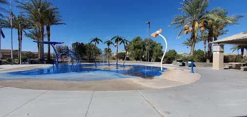 Mobile IV Therapy Las Vegas-A splash pad at a park with water features, palm trees, and a pavilion under a blue sky.