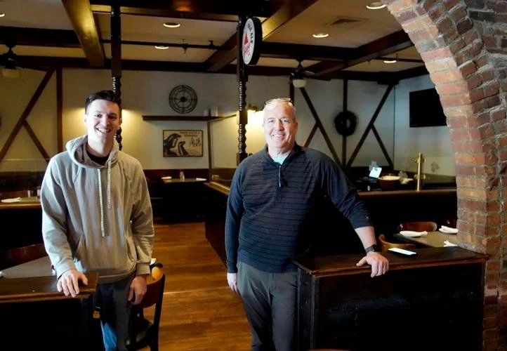 Portrait of restaurant owner with son