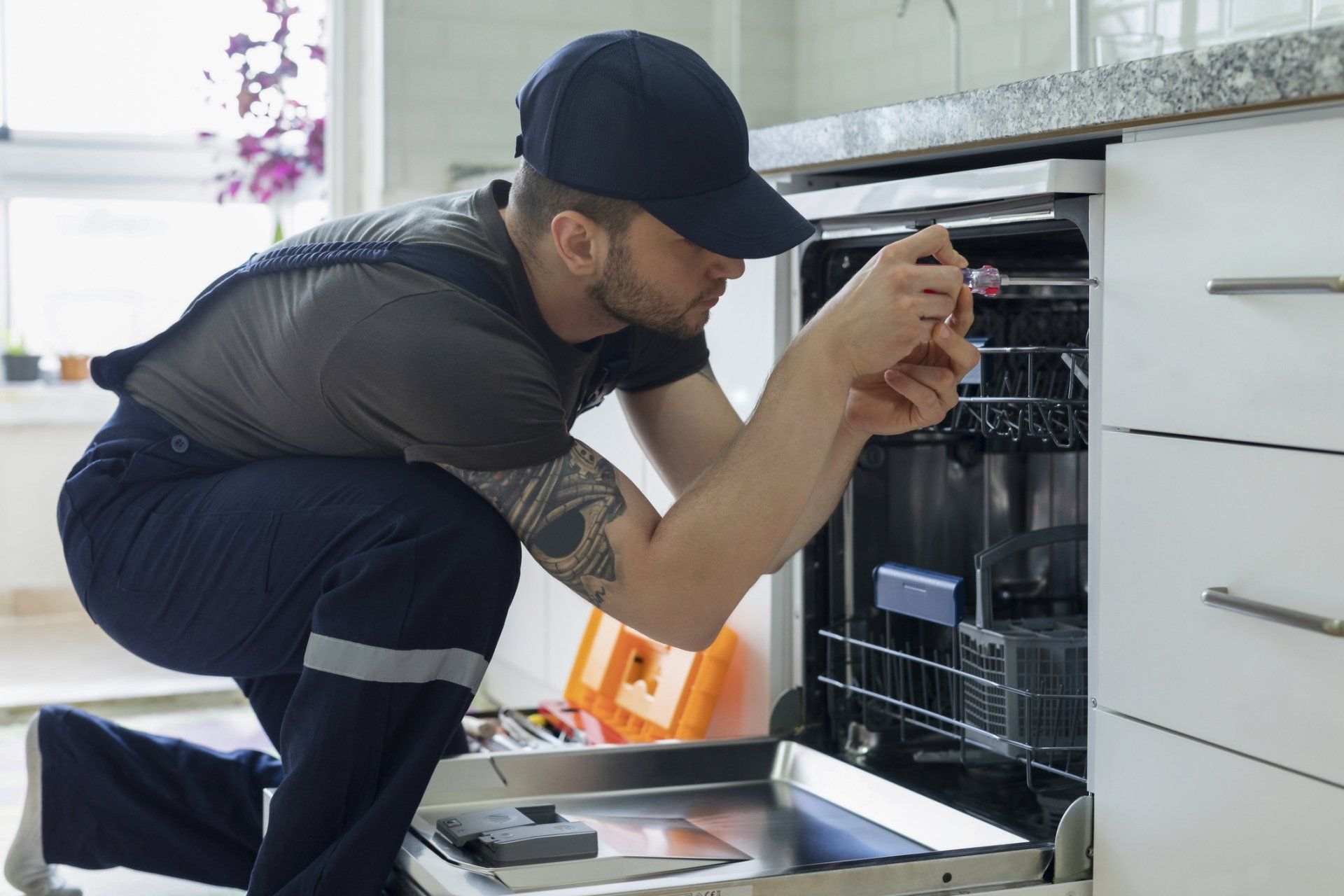 Man Repairing Dishwasher - North Hugo, MN - Northland Appliance & Refrigeration Service & Parts Co.