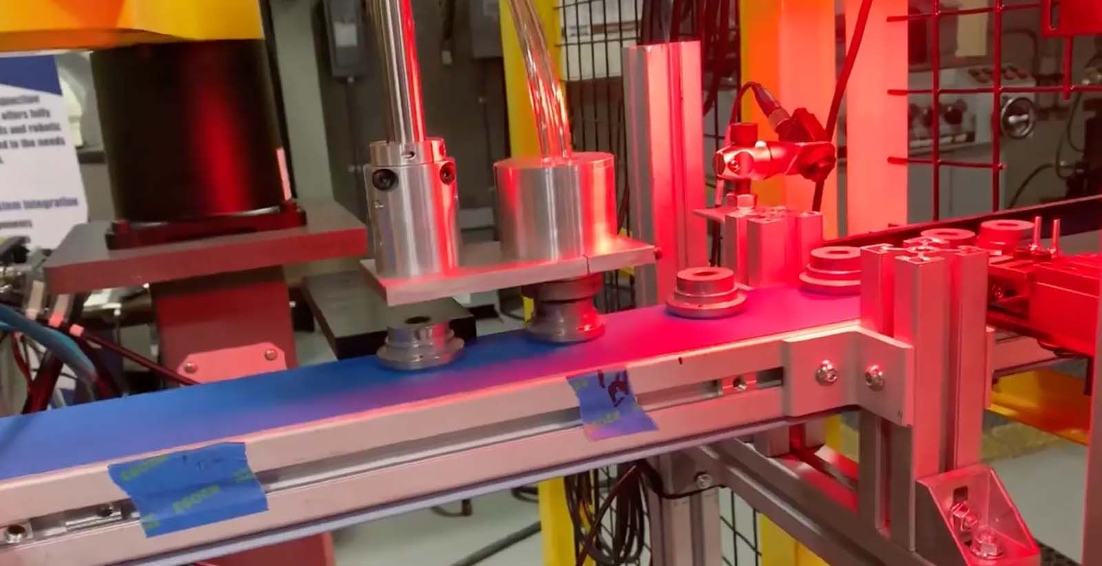 A machine is moving a blue conveyor belt in a factory.