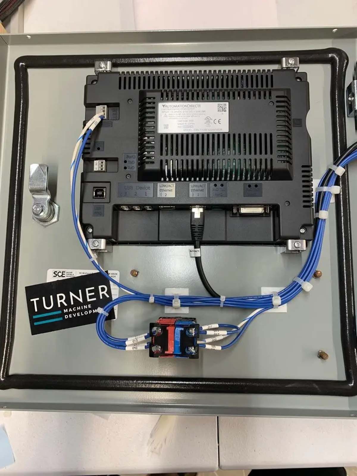 The back of a computer monitor with blue wires coming out of it.