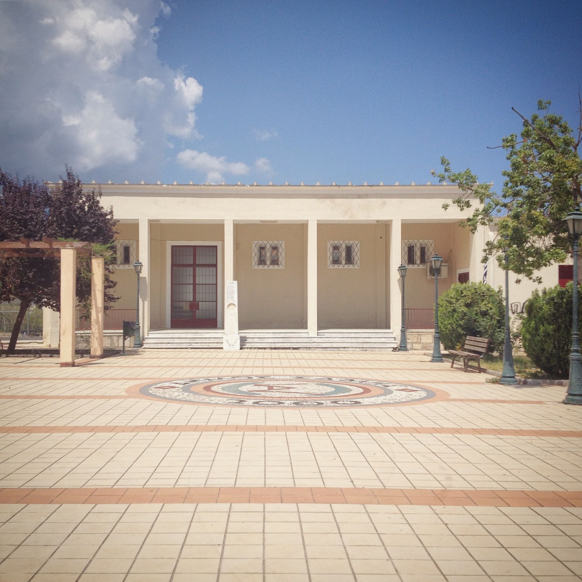 A large building with columns and a mosaic in front of it