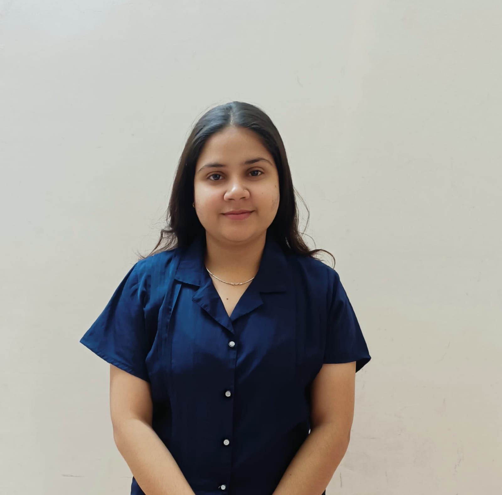 A man is sitting at a table holding a cup of coffee and using a laptop computer.